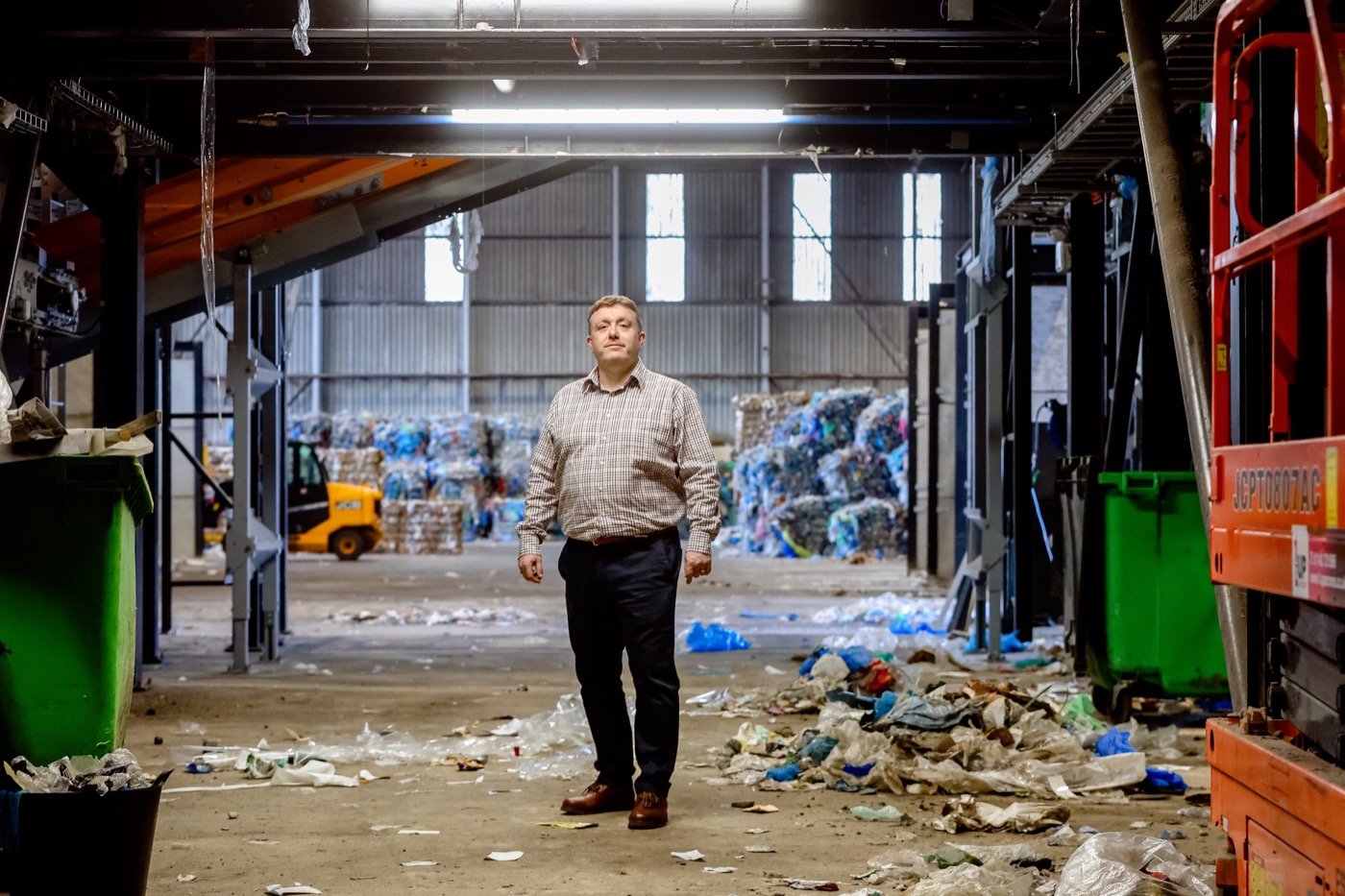 An employer standing on the floor of a recycling plant
